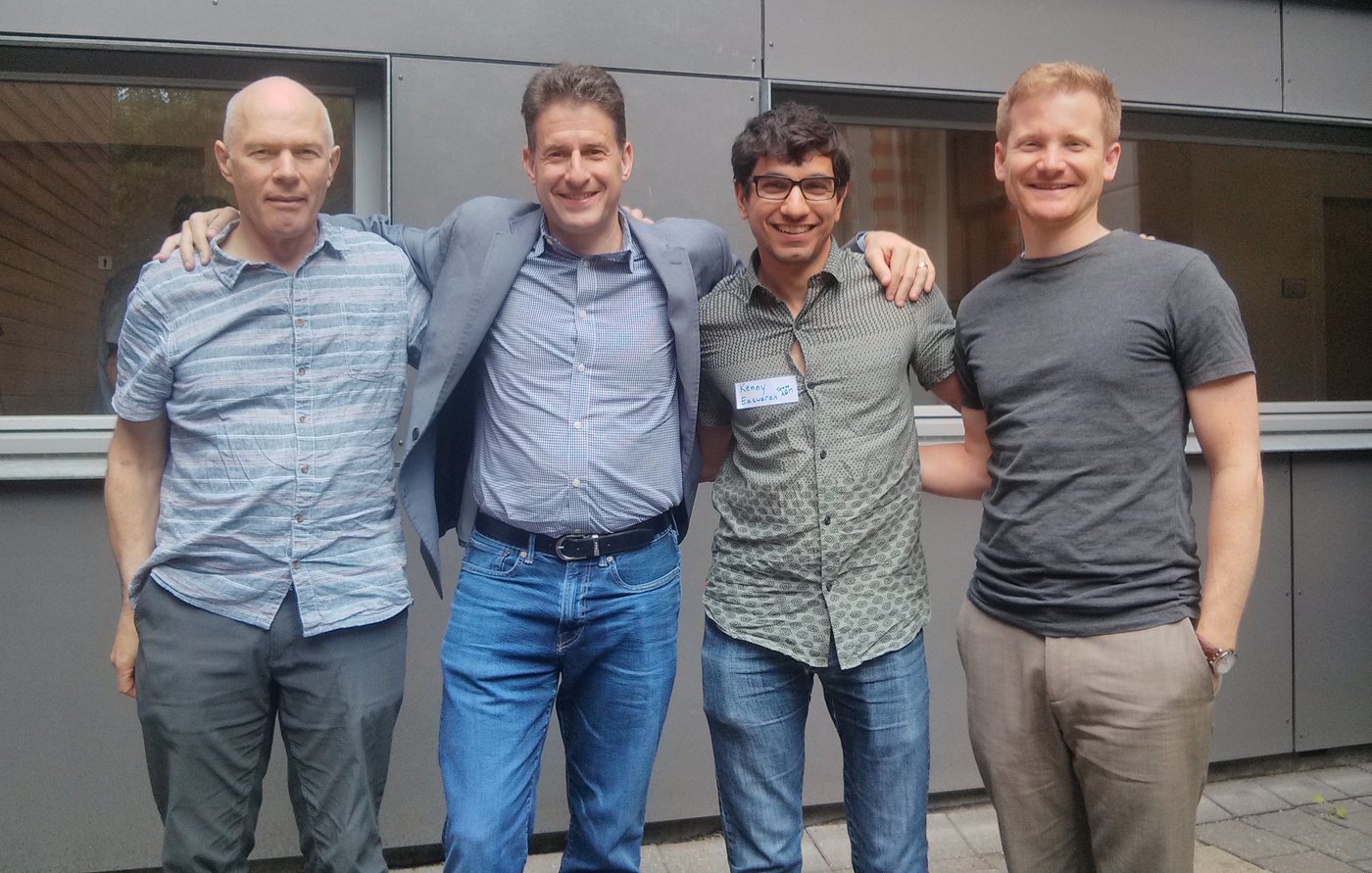 Malcolm Forster, Branden Fitelson, Kenny Easwaran, and Justin Dallmann standing arm in arm outside a building in Groningen