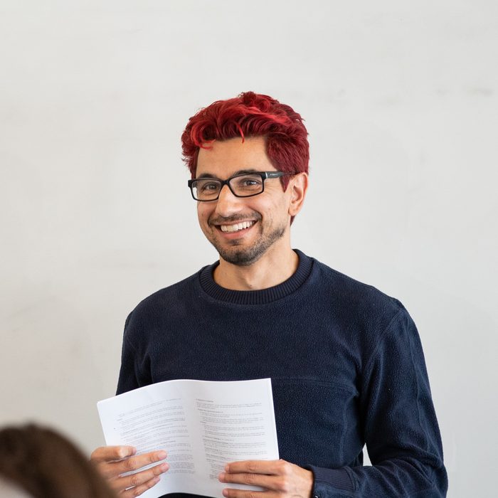 Kenny Easwaran in 2020, with red hair, holding a handout while giving a talk at Princeton