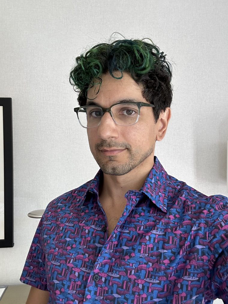 Kenny Easwaran in 2023, with green curly hair and a patterned shirt