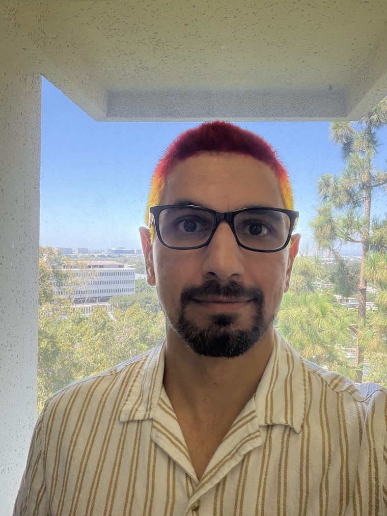 Kenny Easwaran in 2026, with red and yellow hair, on a balcony overlooking the UC Irvine campus